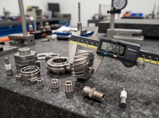 Close up macro of ultra-precision machined metal components and caliper inspection